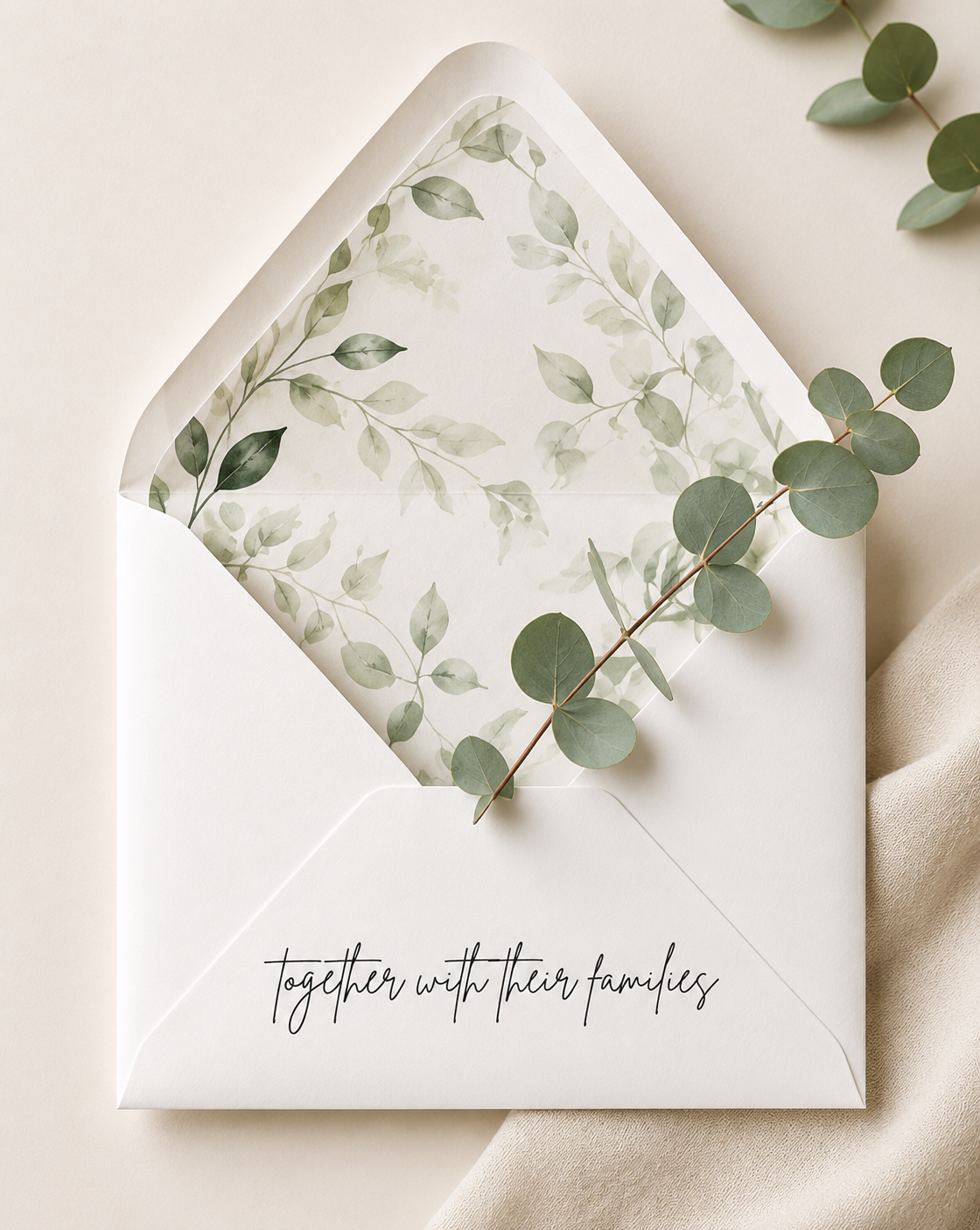 An open envelope with a eucalyptus sprig and the words “together with their families”